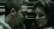 a man and a woman are kissing and hugging in a dark room .