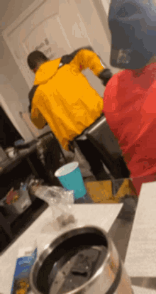 a man in a yellow jacket is standing next to a man in a red jacket