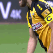 a man wearing a yellow and black jersey with the letter c on the armband