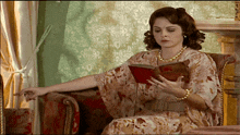 a woman sitting in a chair reading a book