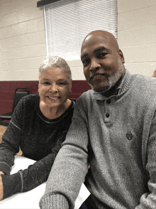 a man and woman are posing for a picture together