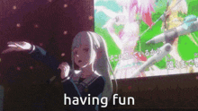 a girl is singing into a microphone with the words having fun behind her