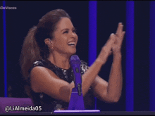 a woman applauds in front of a microphone with the hashtag devoces