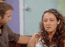a man comforts a woman who is crying on a couch