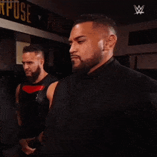 two wrestlers are standing in front of a sign that says process