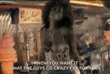a woman is standing in front of an ice cream machine in a diner and talking to a man .