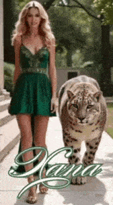 a woman in a green dress is walking next to a large leopard .