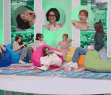 a group of people are sitting on bean bag chairs in front of a green wall