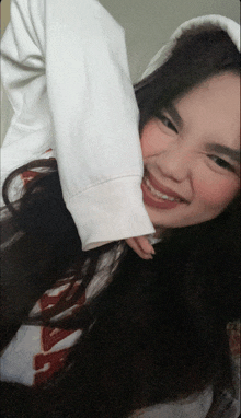 a woman wearing a white hoodie and a shirt that says ' aa ' on it