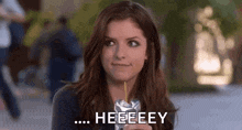 a woman is drinking a drink through a straw and making a face .