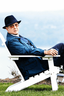 a man wearing a hat and sunglasses is sitting in a white chair