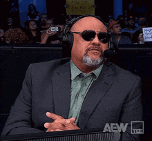 a man wearing a suit and headphones is giving a thumbs down sign