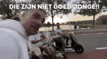two men are riding scooters on a street with the words die zijn niet goed jonge written above them