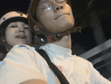a man wearing glasses and a helmet looks up at something