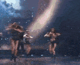 a group of dancers are dancing on a stage in a dark room .