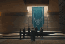 a group of people standing in front of a large blue banner