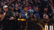 a man in a crowd wearing a shirt that says aew on it