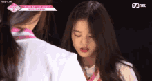 a girl in a white shirt is standing next to a girl in a pink shirt ..