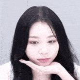 a close up of a woman 's face with her hands on her chin