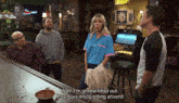 a group of people standing around a bar with a sign that says beer on it
