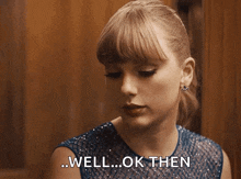 a woman in a blue dress is saying " well ... ok then "