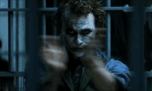 the joker is pointing a gun at the camera