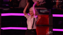a woman in a polka dot shirt and tie is dancing on a stage .