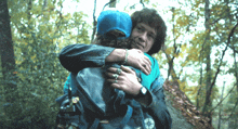 a woman in a blue hat is hugging another woman
