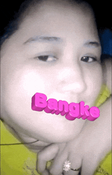 a close up of a woman 's face with bangko written on it