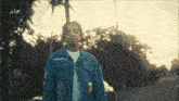 a man in a denim jacket with the word x on the sleeves