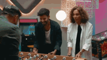 a man and a woman are playing a game with the letters rtve on the ceiling