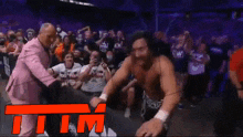 a man in a pink suit is dancing in front of a crowd with the letters tm on the bottom
