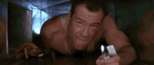 a man is holding a lighter in his hand while crawling through a tunnel .