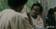 a netflix ad shows two women talking in a prison cell