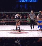 a woman in a wrestling ring with a referee and a sign that says forum in the background