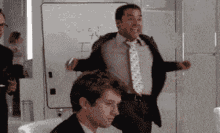 a man in a suit and tie stands in front of a whiteboard that says s = c t
