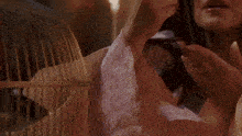 a woman wearing a pearl necklace is holding her chest