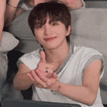a man in a white shirt is giving a thumbs up