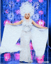 a woman in a white dress is standing on a stage