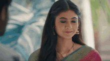 a woman wearing a necklace and earrings is smiling