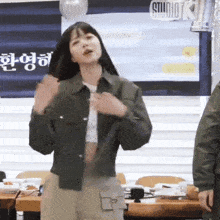 a woman is dancing in front of a sign that says studio k.