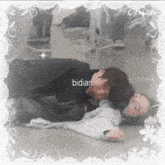 a couple laying on the floor with the word bidian on the bottom right