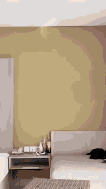a bedroom with a yellow wall and a bed