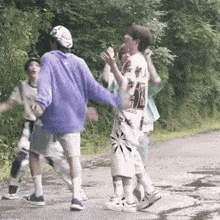 a group of young people are walking down a road .