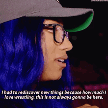 a woman with blue hair is wearing glasses and a hat