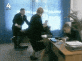 a man in a suit stands next to a woman in an office with the number 4 on the bottom left