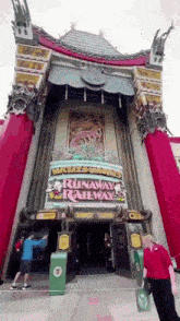 a man standing in front of a building that says runaway railway .