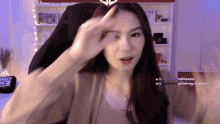 a woman is sitting in front of a screen that says " makakains " on it