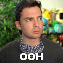 a man wearing a hat and a plaid shirt says ooh on his face