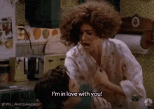 a woman with curly hair is fighting a man in a kitchen .